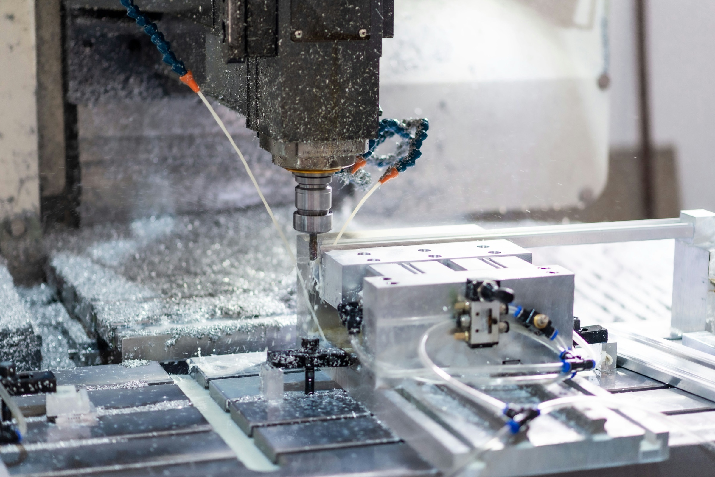 CNC machining center milling an aluminum workpiece under coolant
