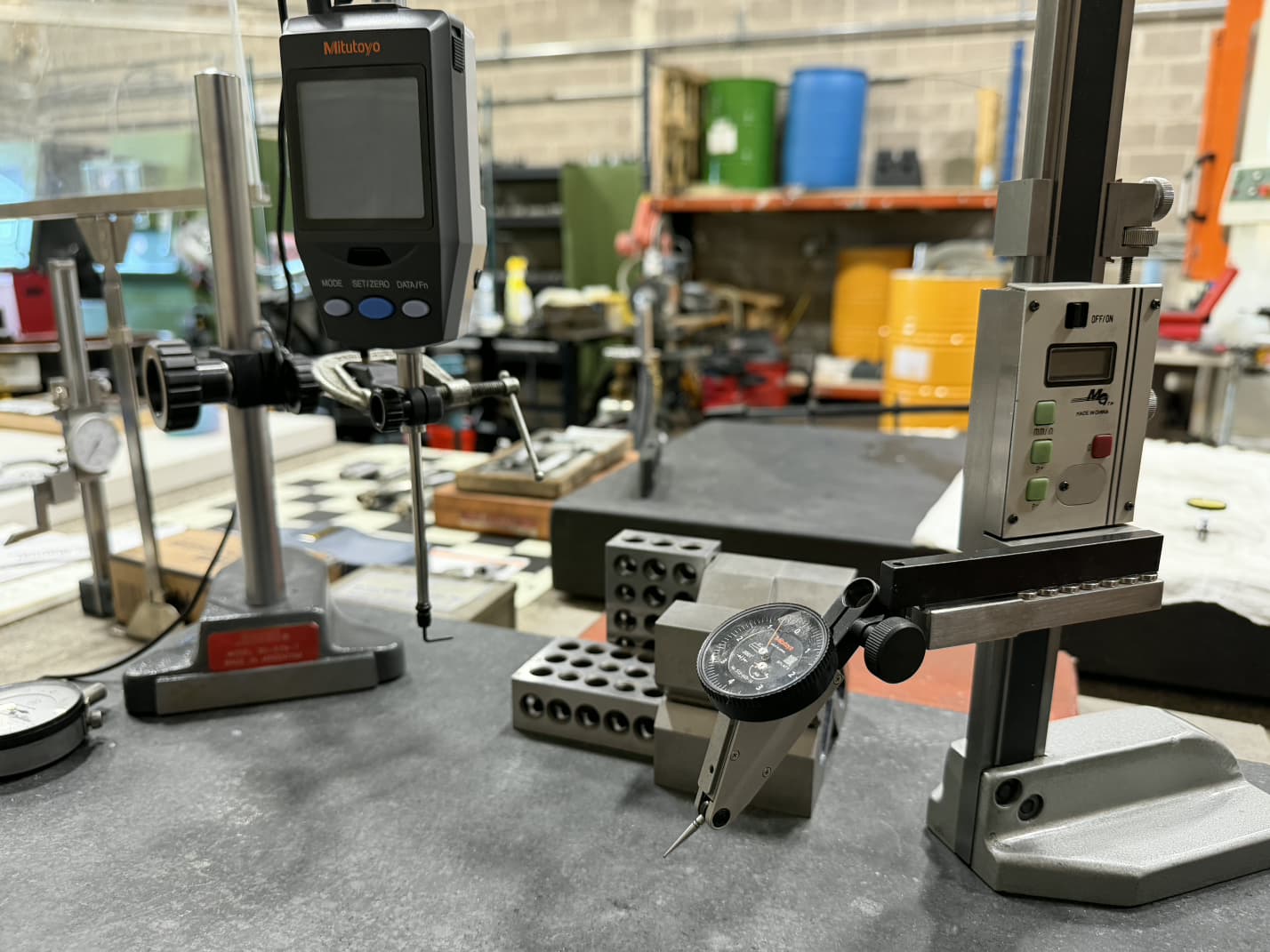 Height gauge, dial test indicator, and 1-2-3 blocks on a granite surface plate