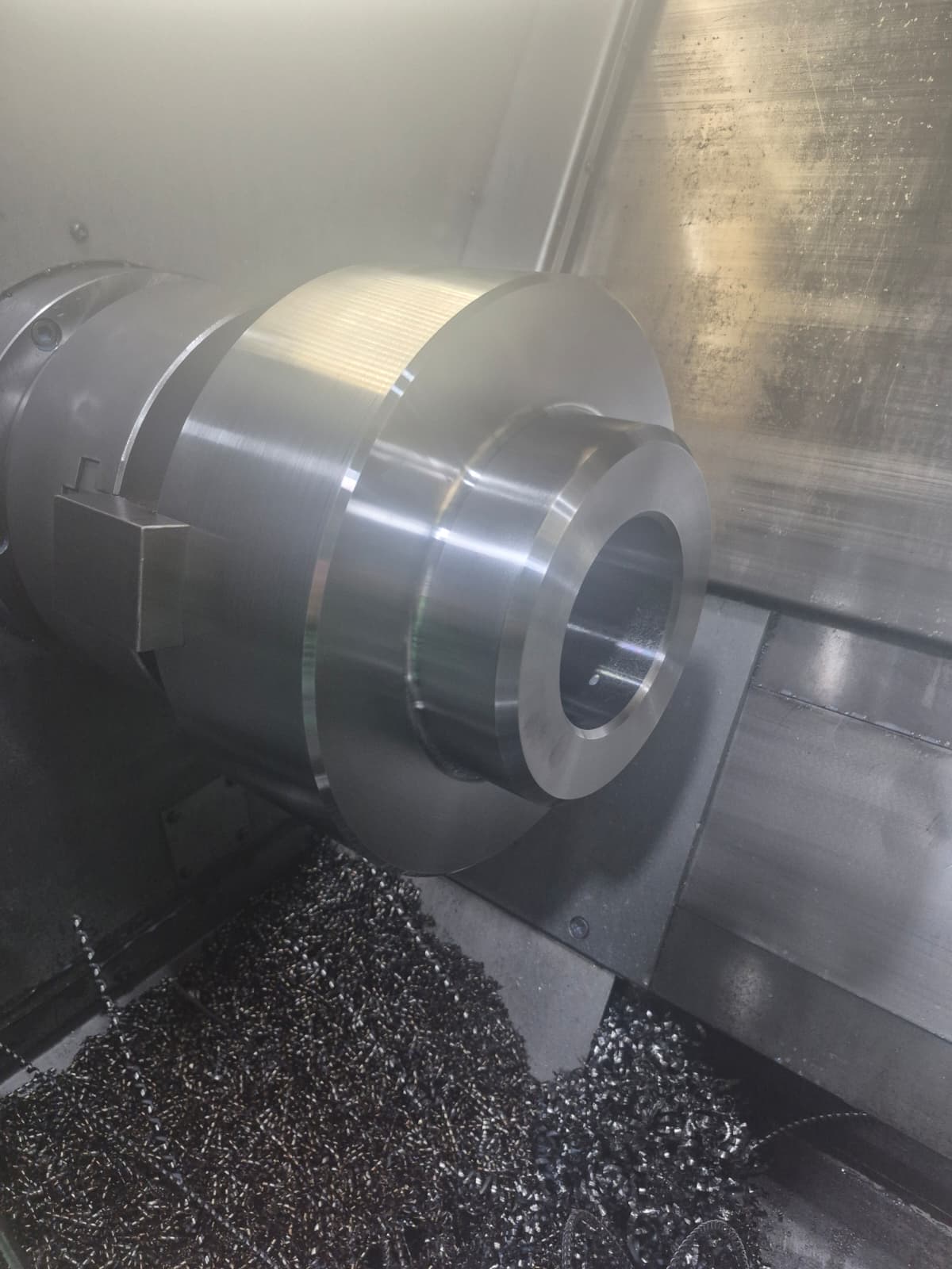 Large steel gear blank being bored on a CNC turning center