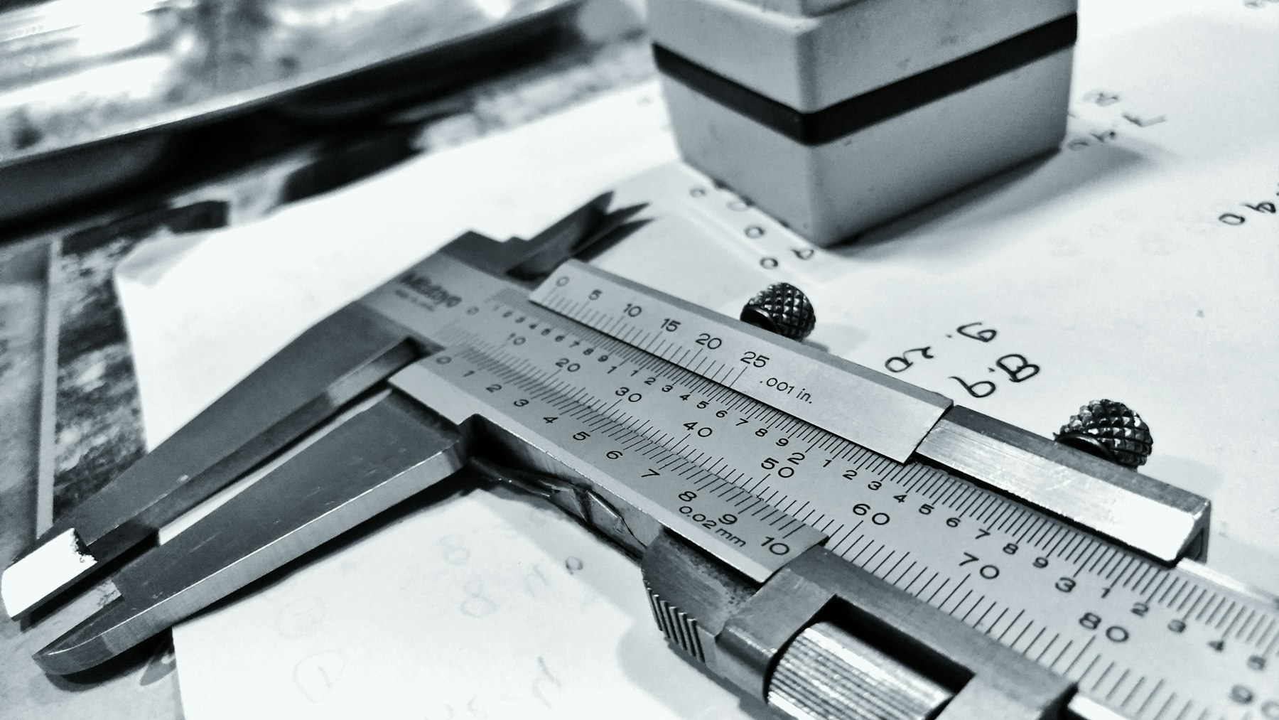 Vernier caliper and steel rule on a workbench