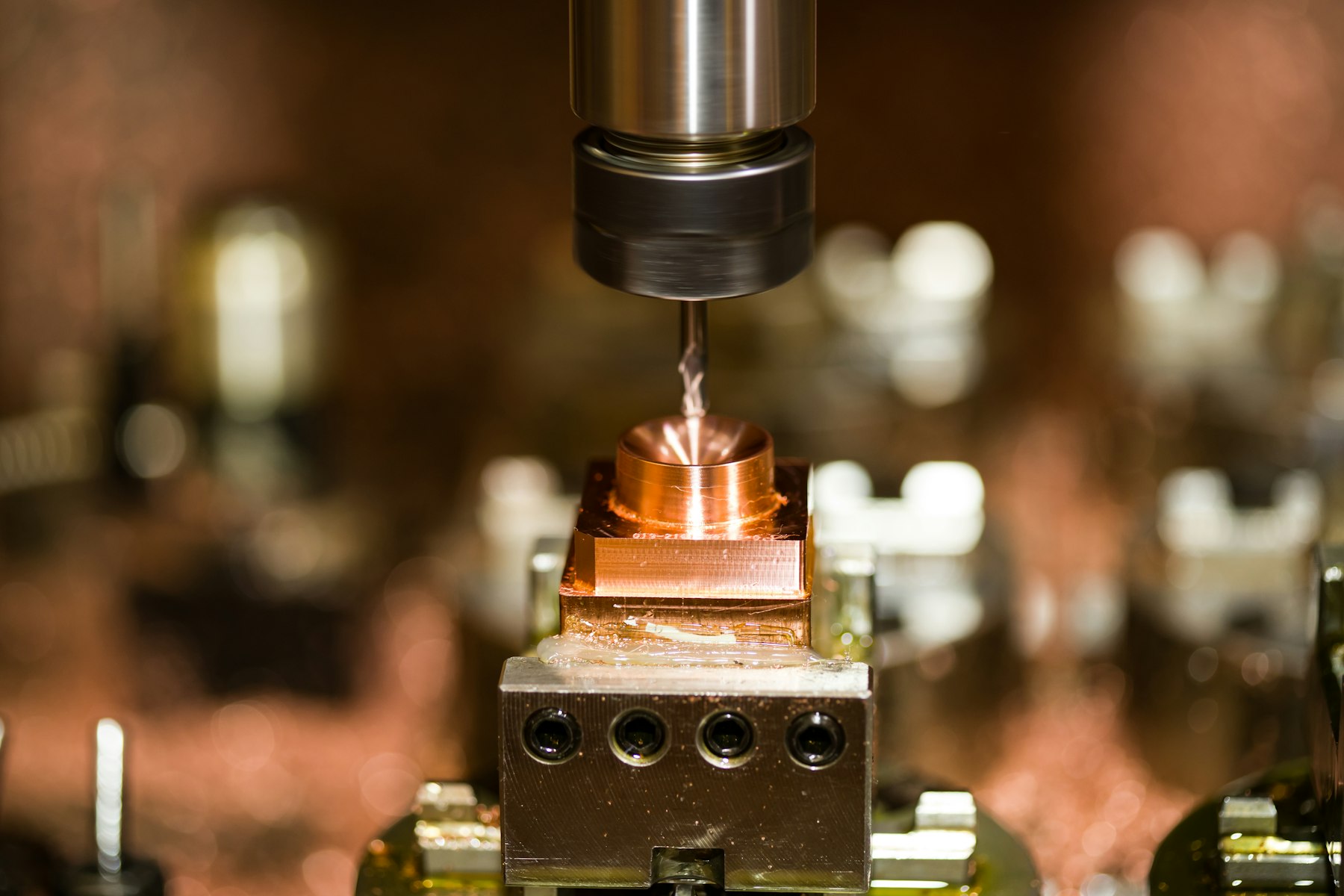 Copper block clamped in a machine vise under an end mill
