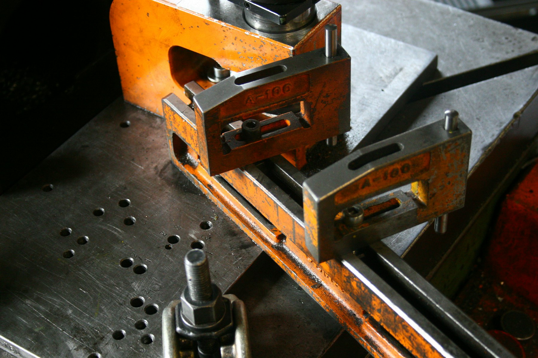 Steel strap clamps holding a workpiece on a machine table
