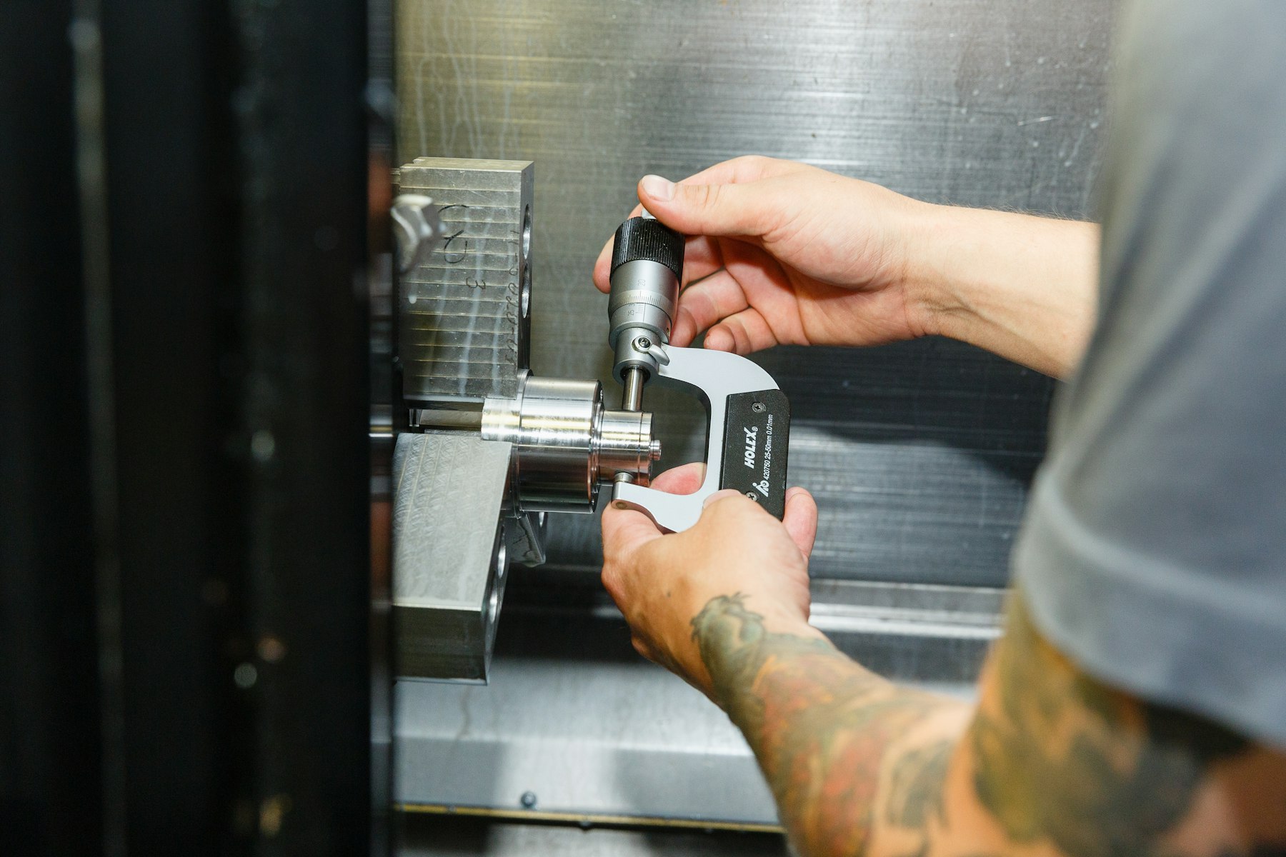 Machinist checking a turned part with an outside micrometer