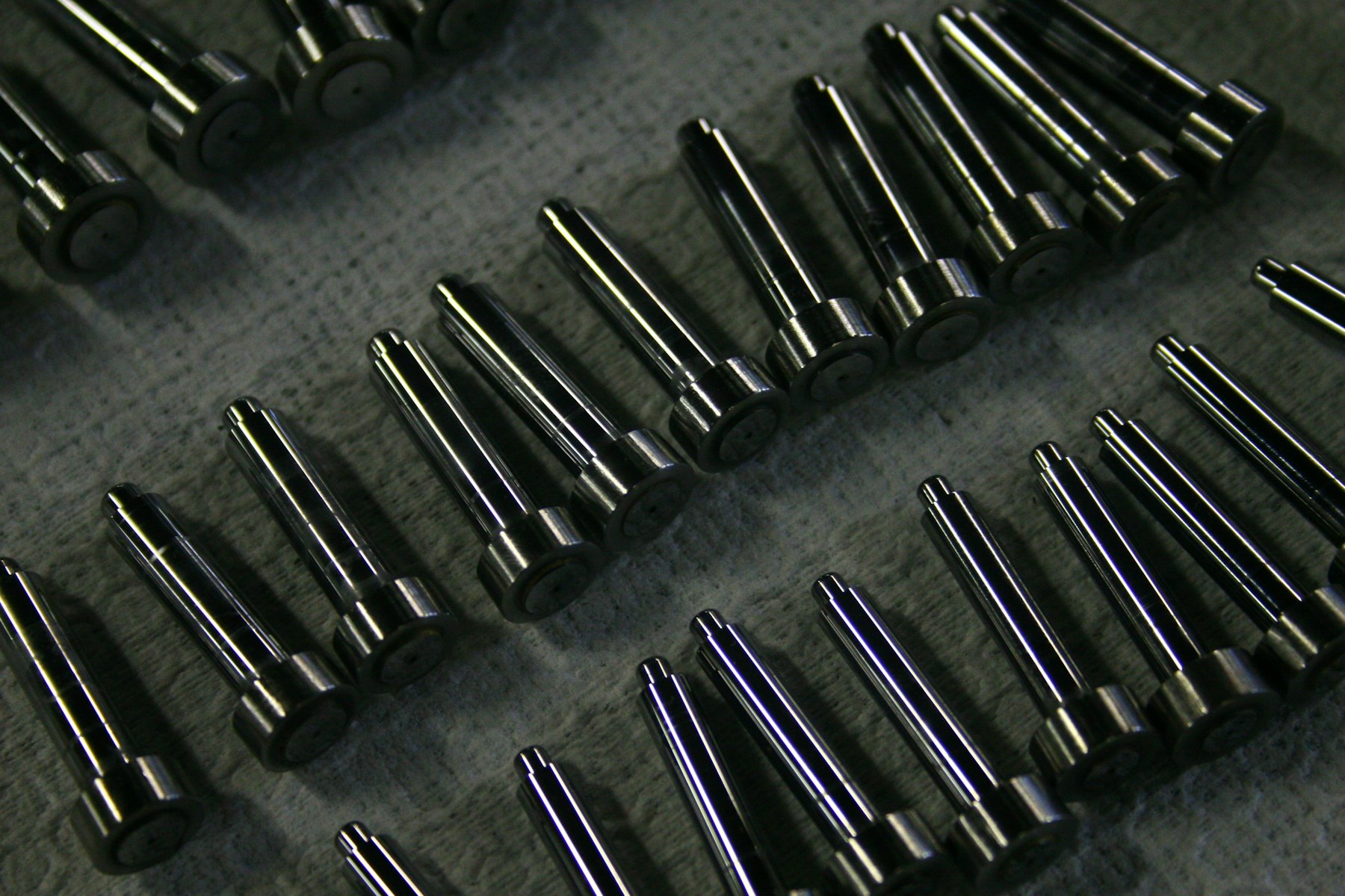 Rows of identical machined metal components laid out after a production run