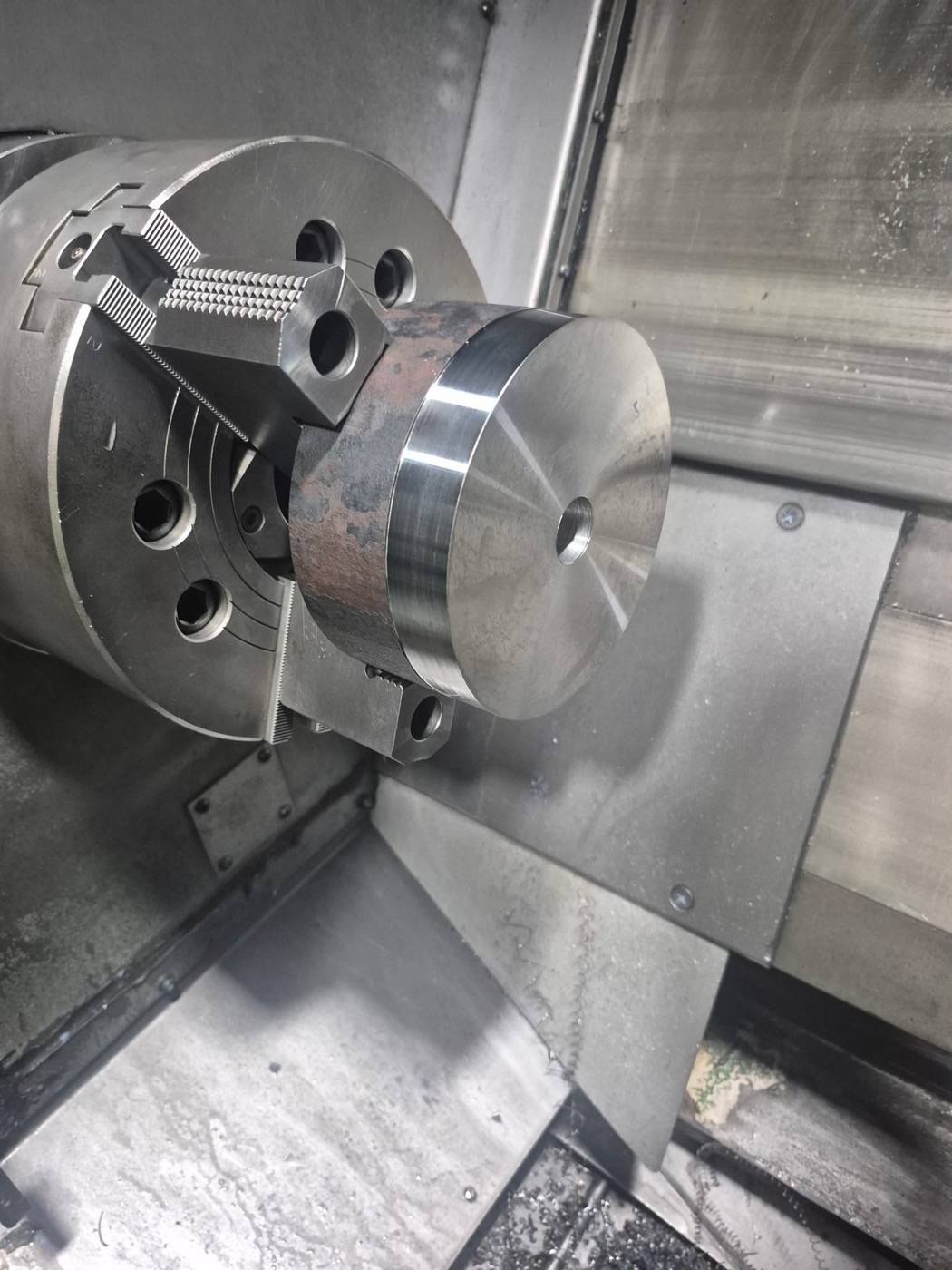 Faced and turned round steel blank gripped in the three-jaw hydraulic chuck